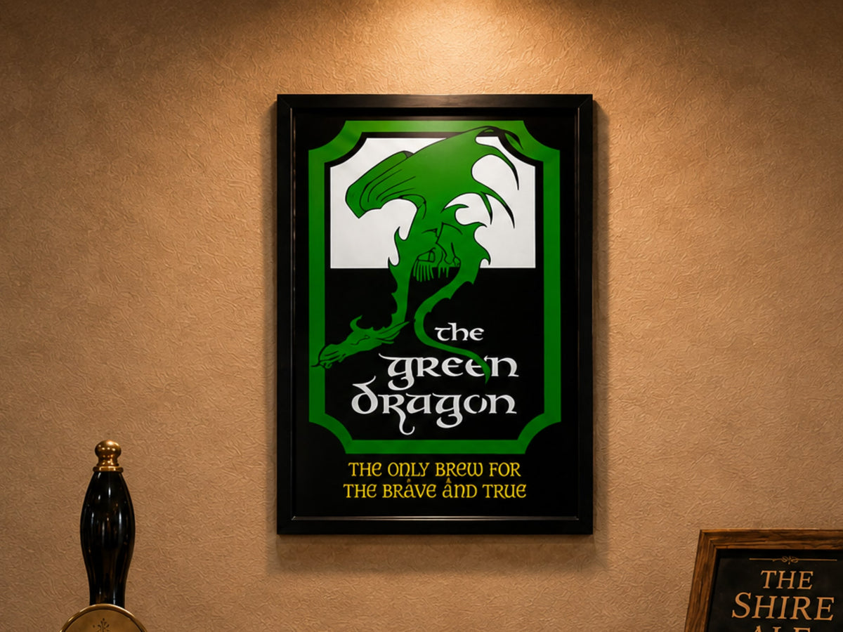 Black framed print of the green and white Green Dragon pub sign, "The Only Brew for the Brave and True", on a bar wall