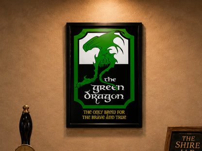 Black framed print of the green and white Green Dragon pub sign, "The Only Brew for the Brave and True", on a bar wall