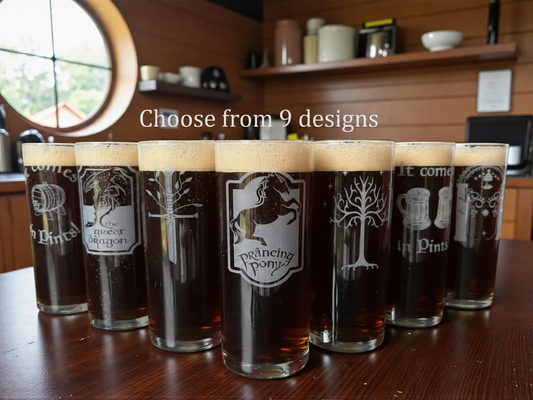 Seven highball glasses of dark beer engraved with Prancing Pony, Green Dragon, White Tree and other designs