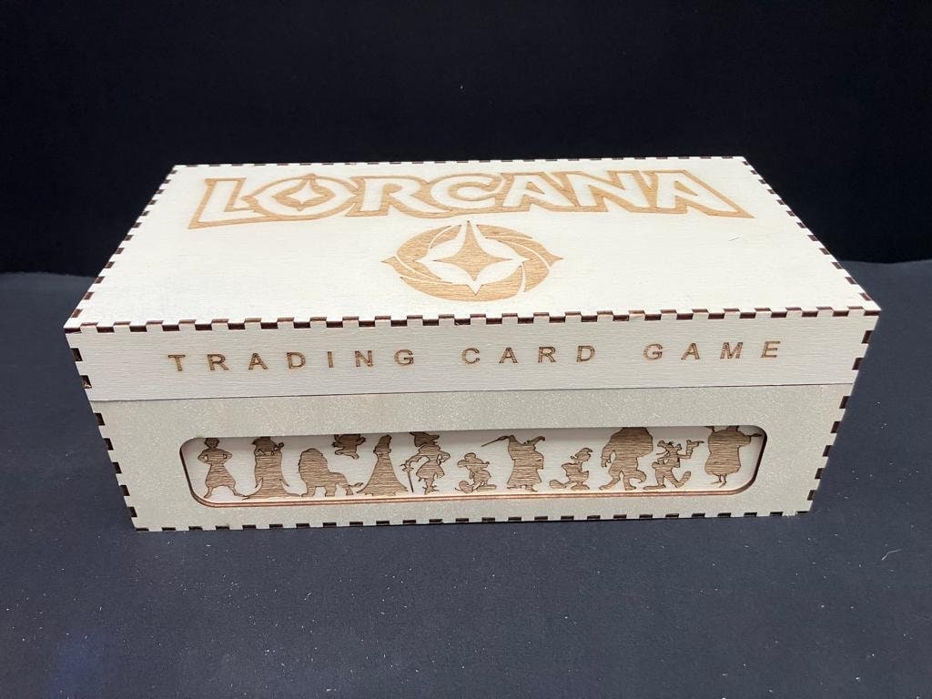Natural wooden box with Lorcana and Trading Card Game engraved on the lid and front, and a row of character silhouettes