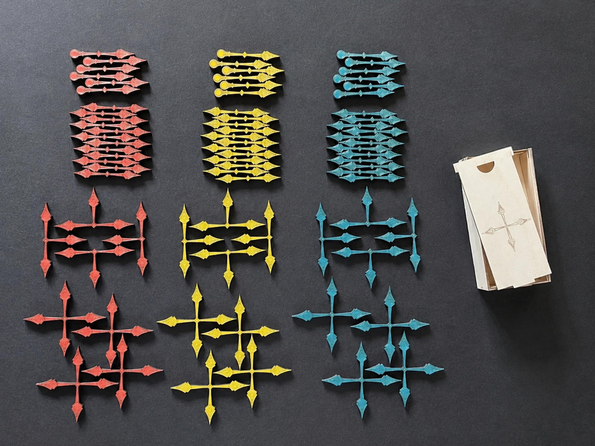 Red, yellow and teal arrow pointers in single to quadruple shapes, beside a wooden storage box with compass lid