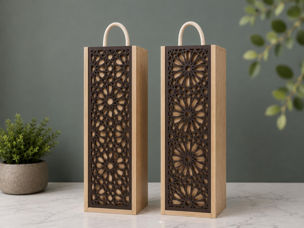 Two wooden wine boxes with rope handles and dark geometric cut-out front panels on a marble surface
