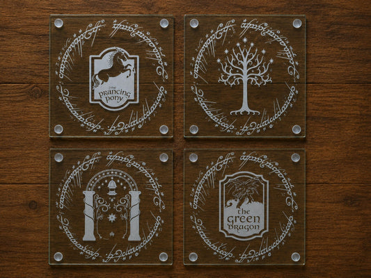 Four glass coasters engraved with the Prancing Pony, White Tree, Gate of Moria and Green Dragon in elvish script rings