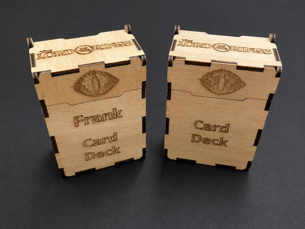 Two natural wooden deck boxes engraved with a fiery eye and Card Deck, one with the name Frank, title along the top